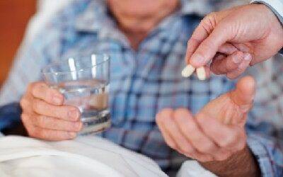 closeup-of-an-elderly-man-being-given-pills-focus-on-the-medicine